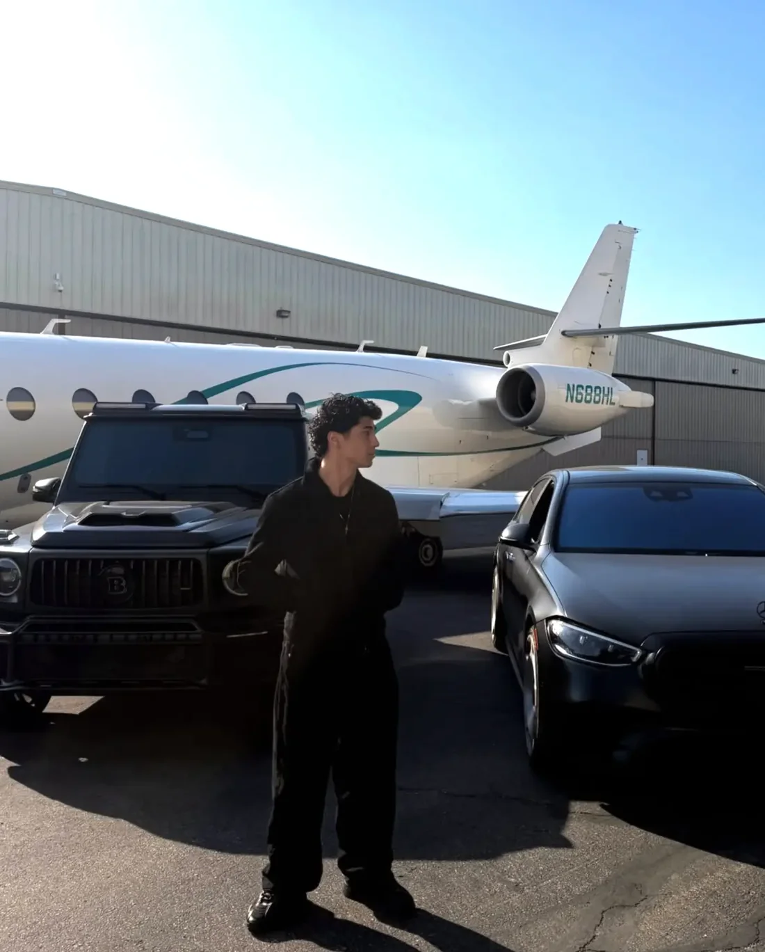 Hakim Saif standing in front of a private jet